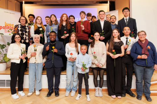 Man sieht den gewählten Jugendbeirat, die Schüler halten jeweils eine Rose in der Hand